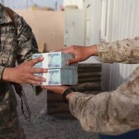  | US Marine Corps Cpl David Che right a supply warehouse clerk with Headquarters and Service Company 1st Marine Logistics Group Forward hands Afghan currency to Army 1st Lt Manuel Jimenez April 7 2014 | MR Online